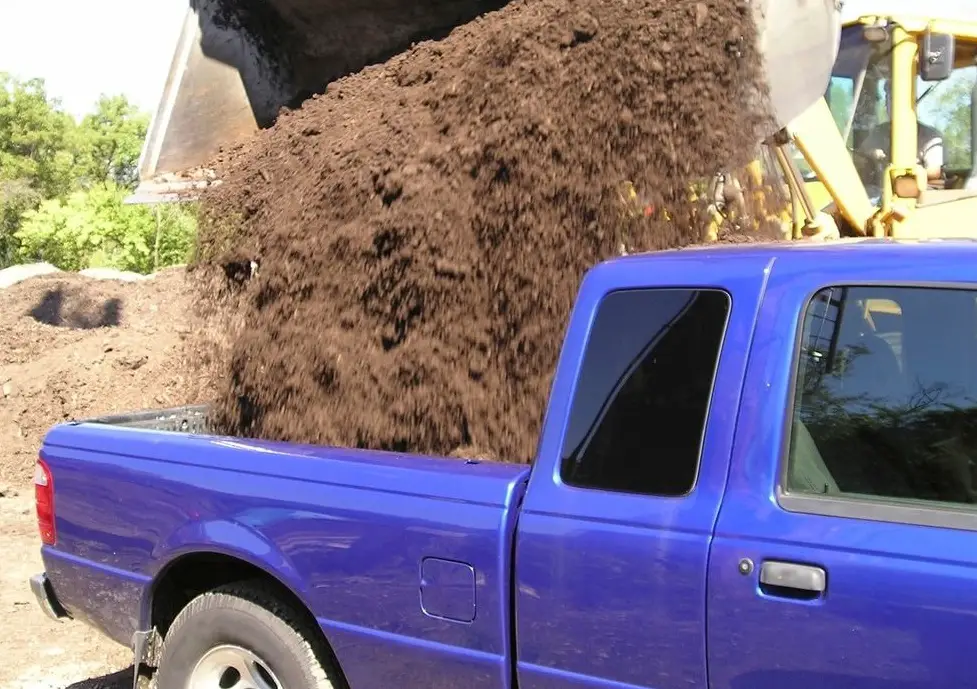 blue truck with dirt in bed